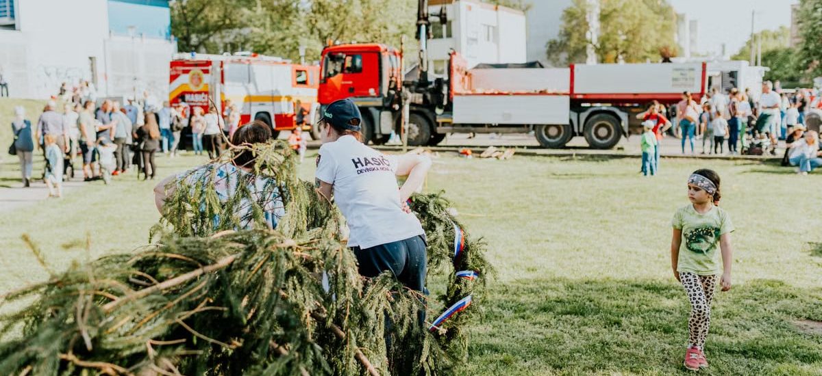 A lively outdoor community event featuring fire trucks, families, and a festive atmosphere.
