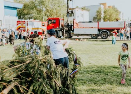 A lively outdoor community event featuring fire trucks, families, and a festive atmosphere.