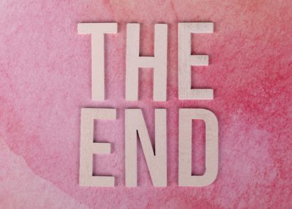 Elegant 'The End' text on a textured pink background, perfect for closure or transition concepts.
